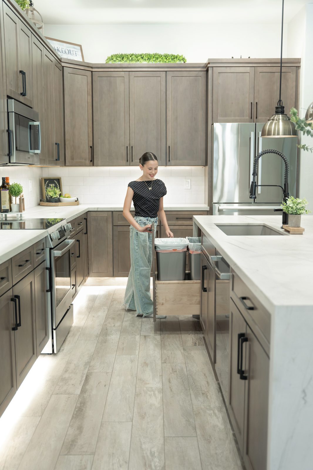 Pull-out trash and recycling drawer, a semi-custom cabinetry detail installed by Markell Designs