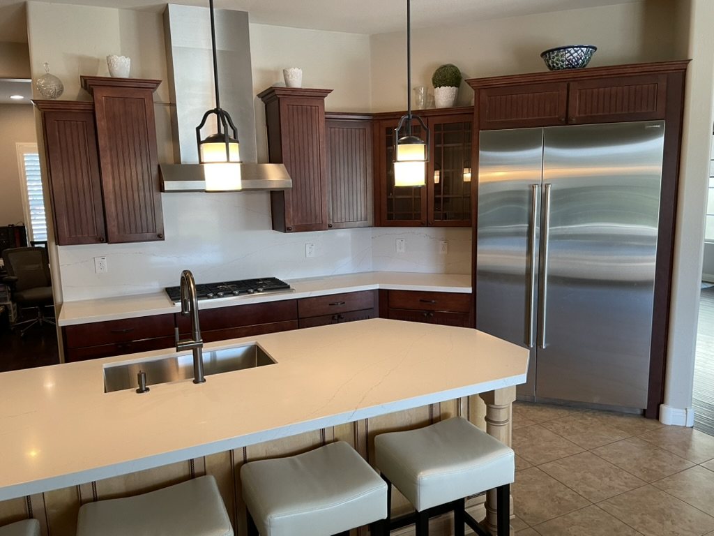 Quartz kitchen with dark cherry cabinetry and full-height backsplash, Chandler, AZ